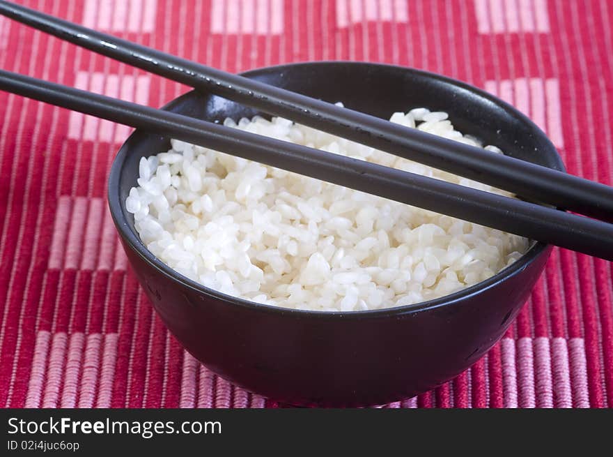 Plain rice bowl, chopsticks, on red background