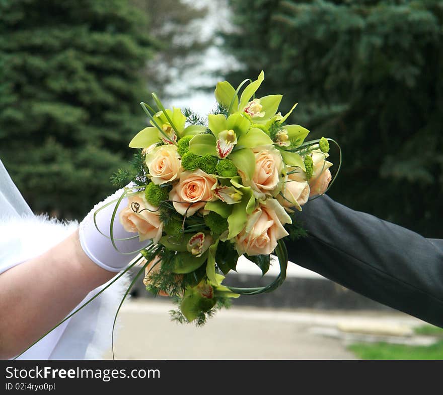 Bridal bouquet in the hands of the bride and groom