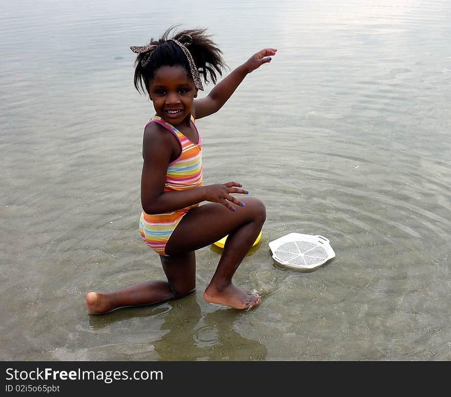 A beautiful black little girl playing on the beach. A beautiful black little girl playing on the beach.