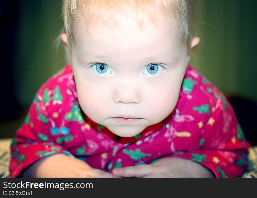 Beautiful little baby with blond hair and blue eyes.