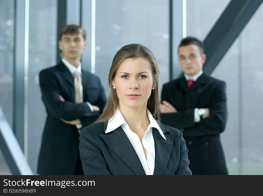 A young business woman in front of her colleagues in a modern office. A young business woman in front of her colleagues in a modern office.