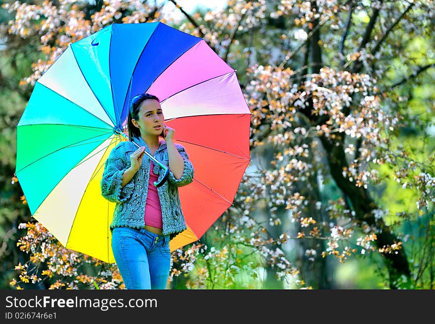 Beautiful woman with umbrella in rainbow colors