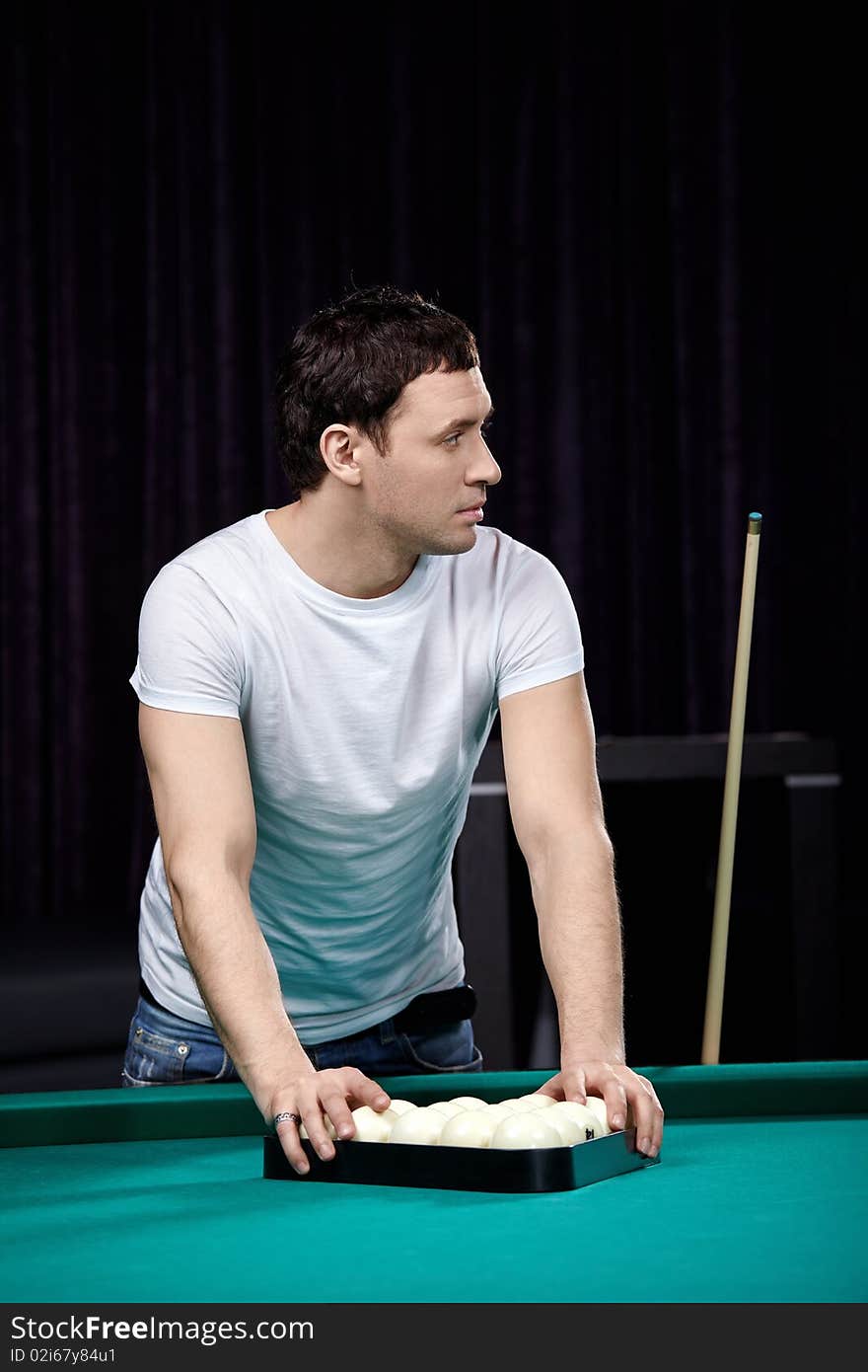 The young attractive man is going to play billiards. The young attractive man is going to play billiards