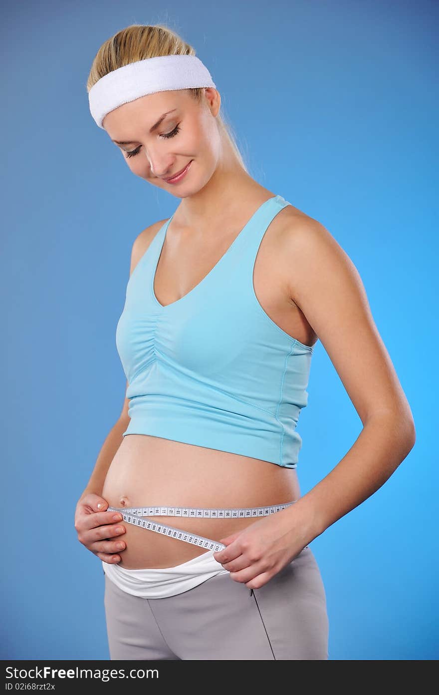 Pregnant woman measures her belly