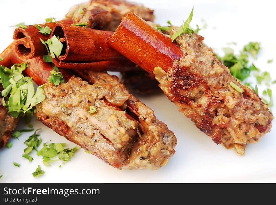 Kebab on cinnamon sticks on white background