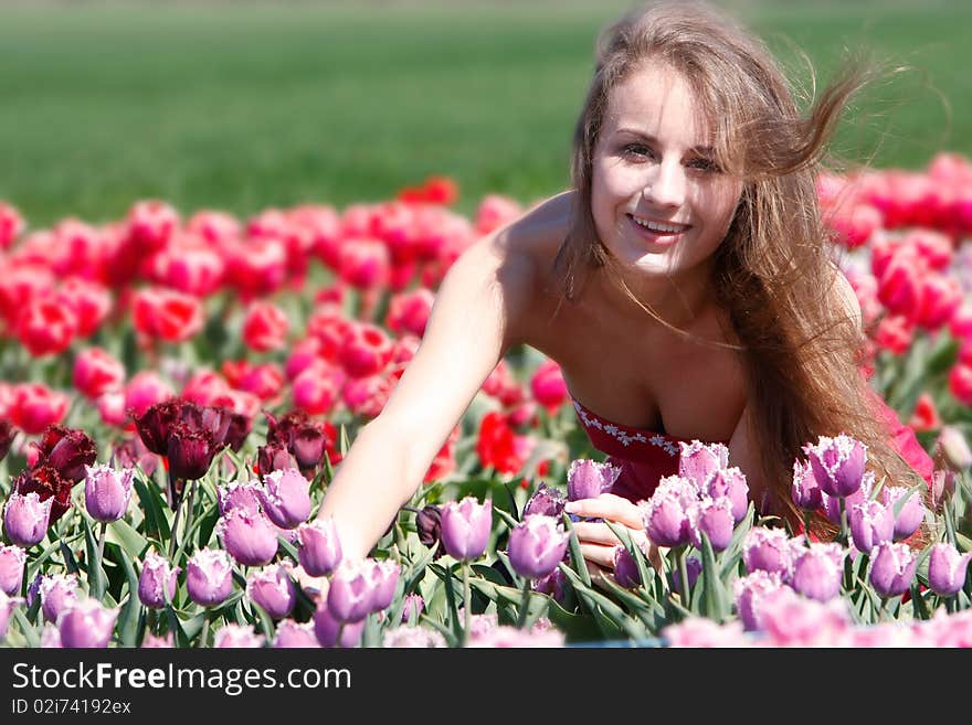 Happy girl in red and purple tulips