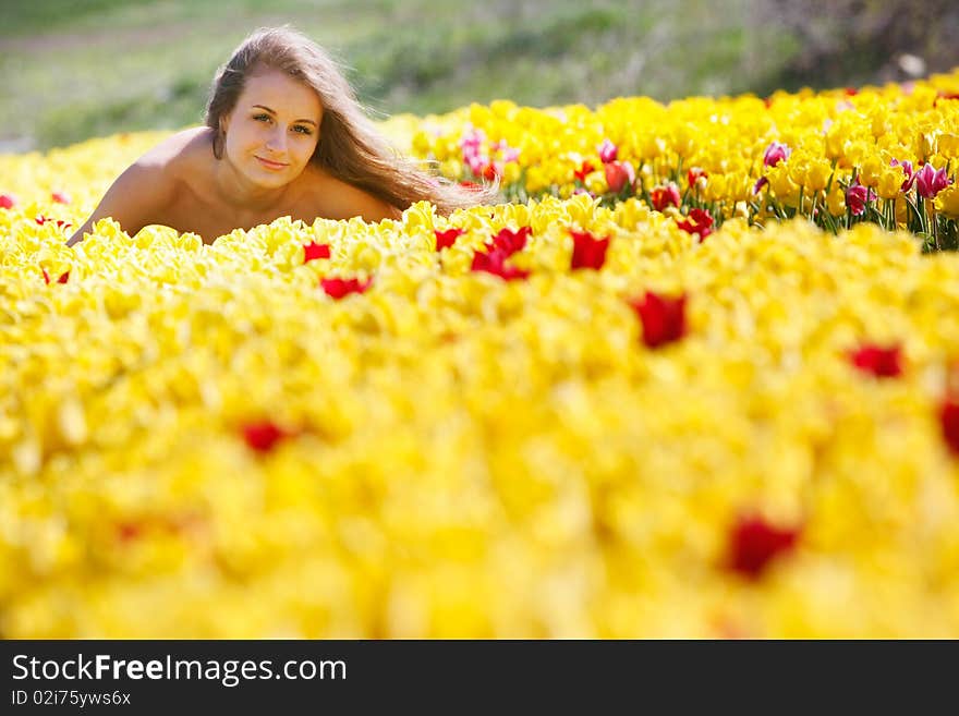 Young beautiful girl in yellow tulips