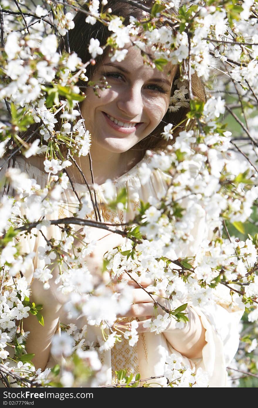 Young beautiful girl in spring flowers