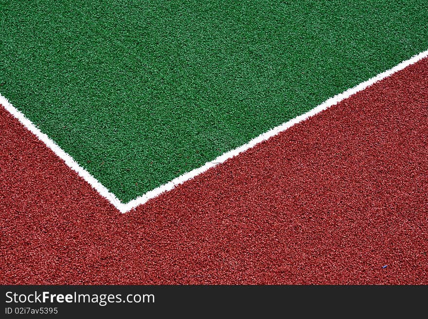 Red racetrack and green sports field with artificial grass. Red racetrack and green sports field with artificial grass