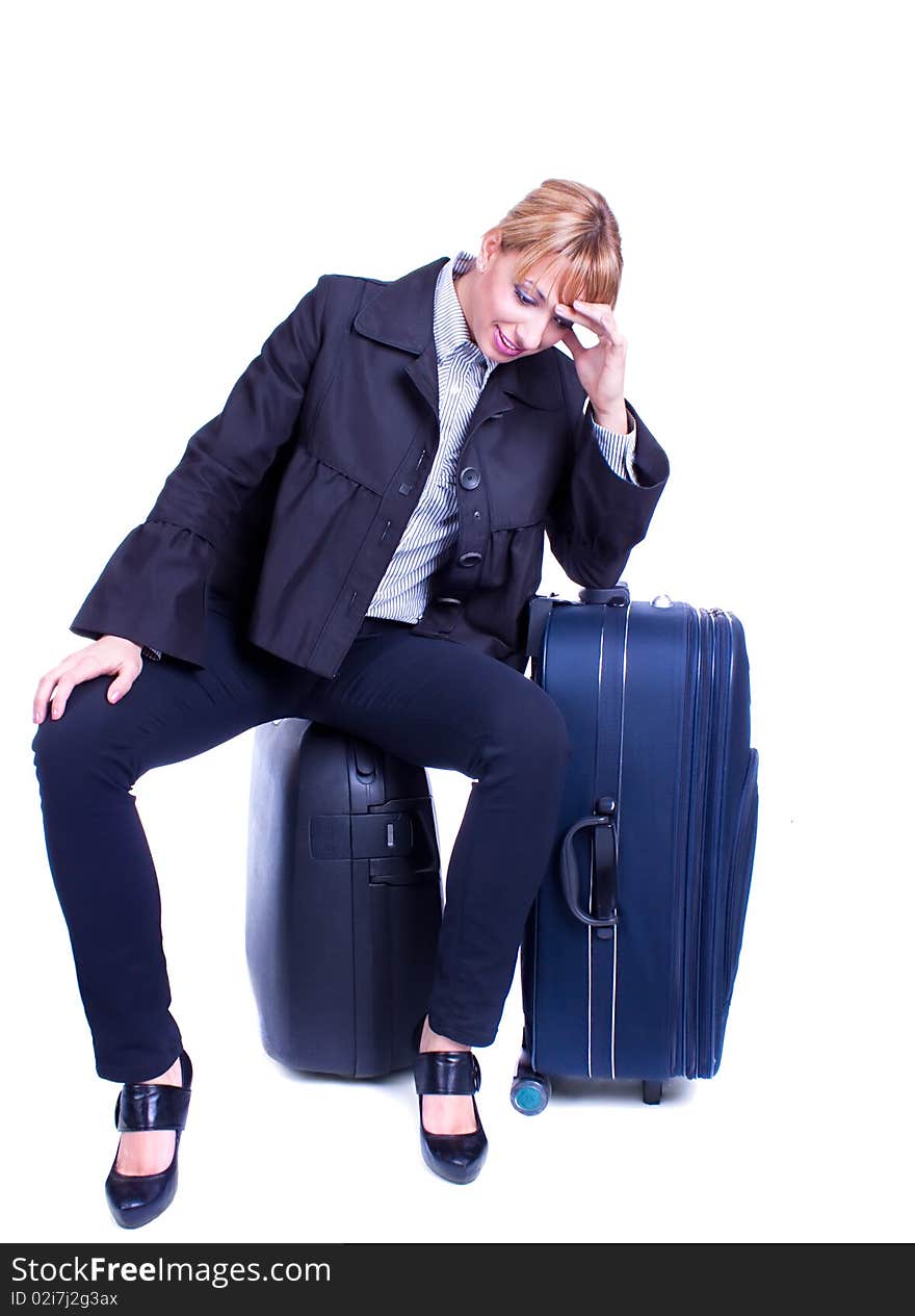 Businesswoman sits on black suitcase and waiting