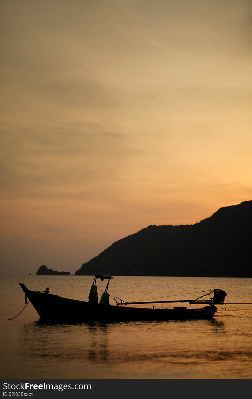 An non-occupied boat floating on the calm warming sea in the morning. An non-occupied boat floating on the calm warming sea in the morning.