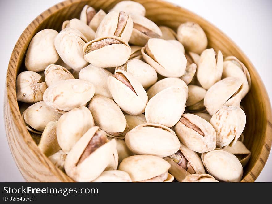 Many natural pistacios on brown bowl