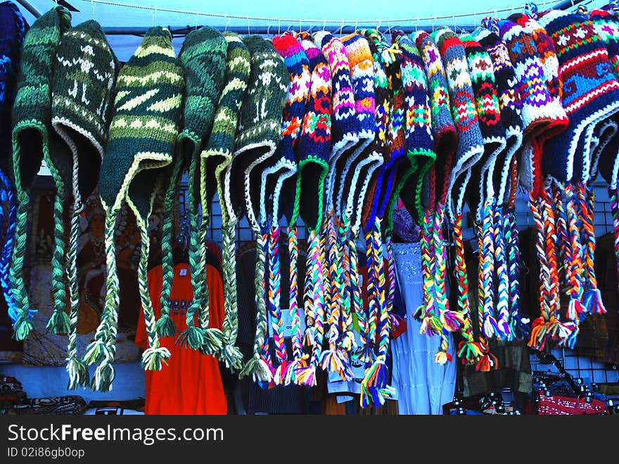 A row of colorful hand knit hats for sale at the fair.