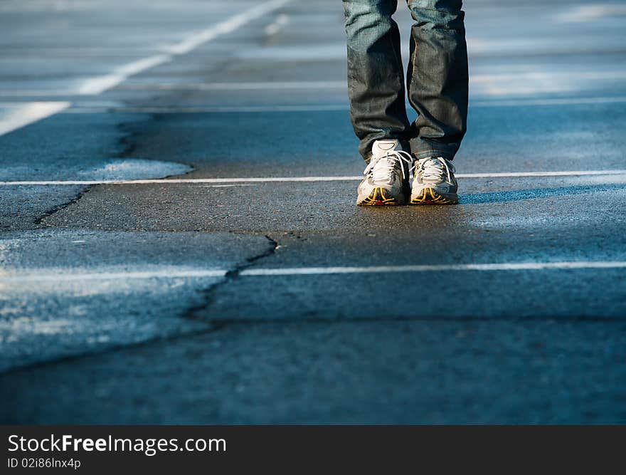 Human legs in sneakers standing on square. Human legs in sneakers standing on square