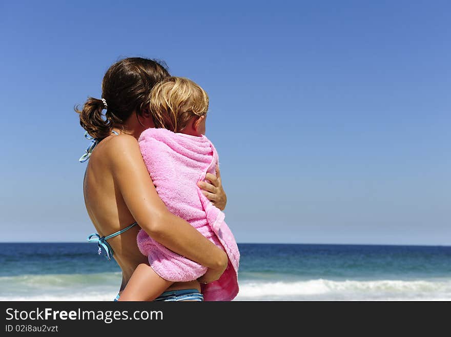 Summer vacation on the beach: mother carrying her daughter. Summer vacation on the beach: mother carrying her daughter