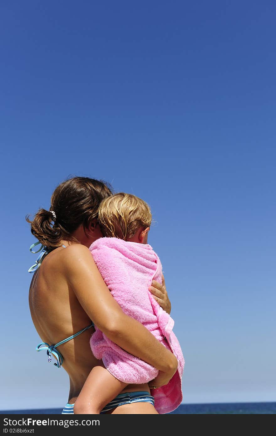 Summer vacation on the beach: mother carrying her daughter. Summer vacation on the beach: mother carrying her daughter