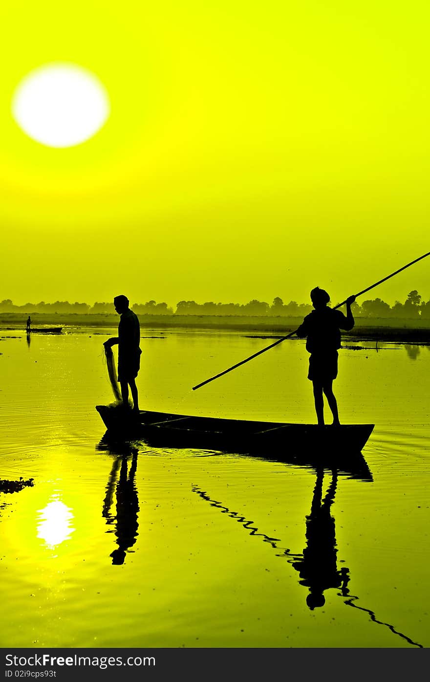 A silhouette fishermen on a boat at sundown. A silhouette fishermen on a boat at sundown