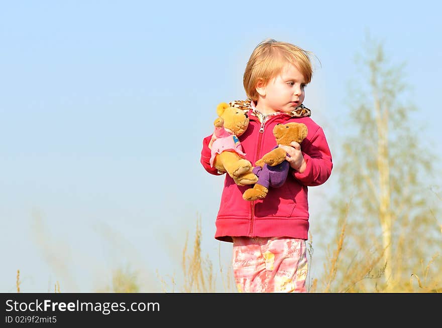 Kid girl with two toy bears in his hands