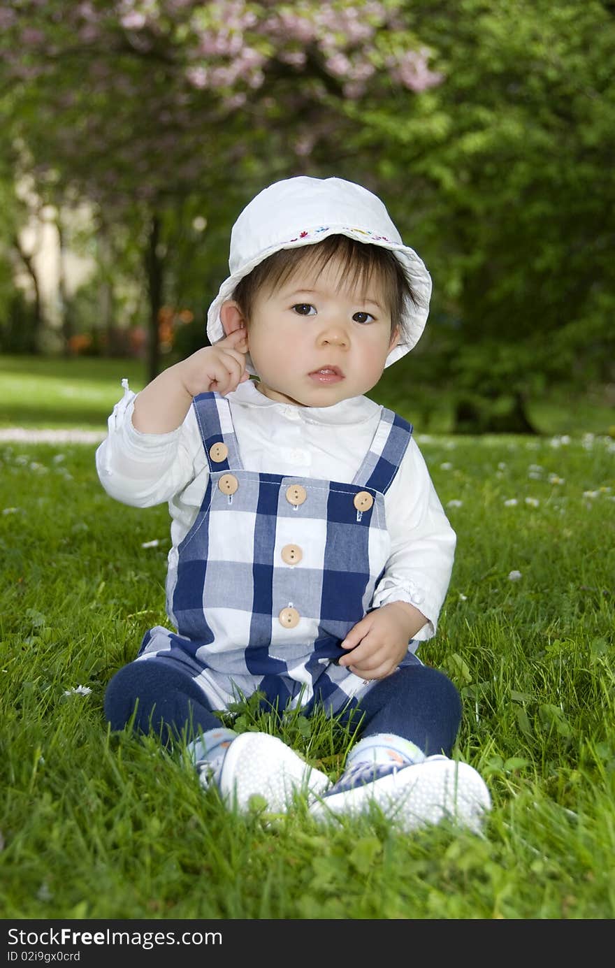 Cute little girl sitting in garden