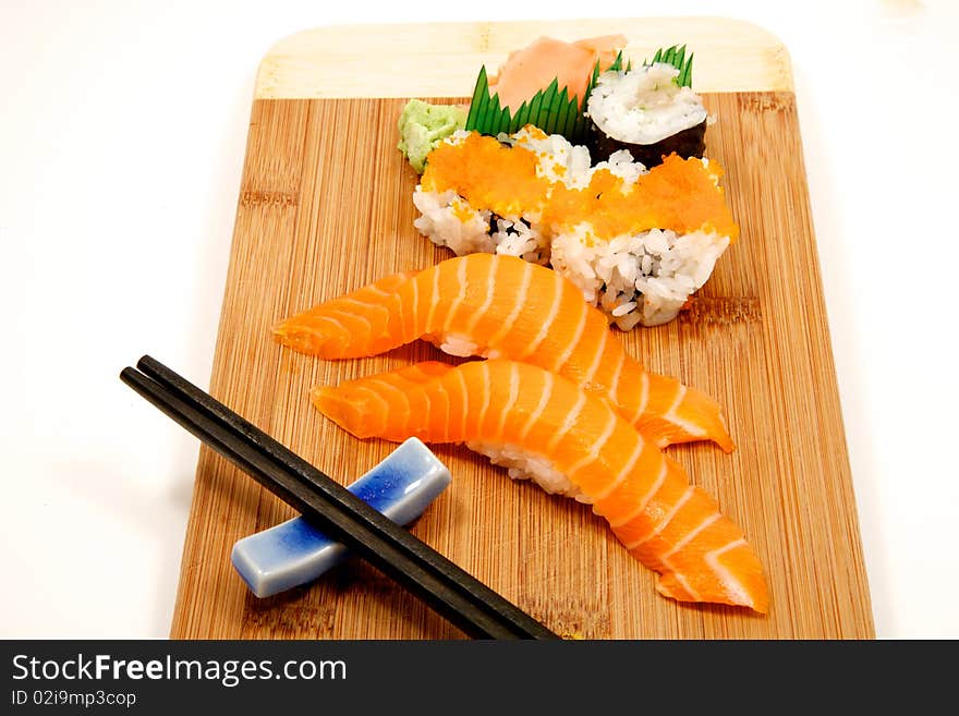 Fresh sushi on a bamboo board with chop sticks, ginger and wasabi. Fresh sushi on a bamboo board with chop sticks, ginger and wasabi