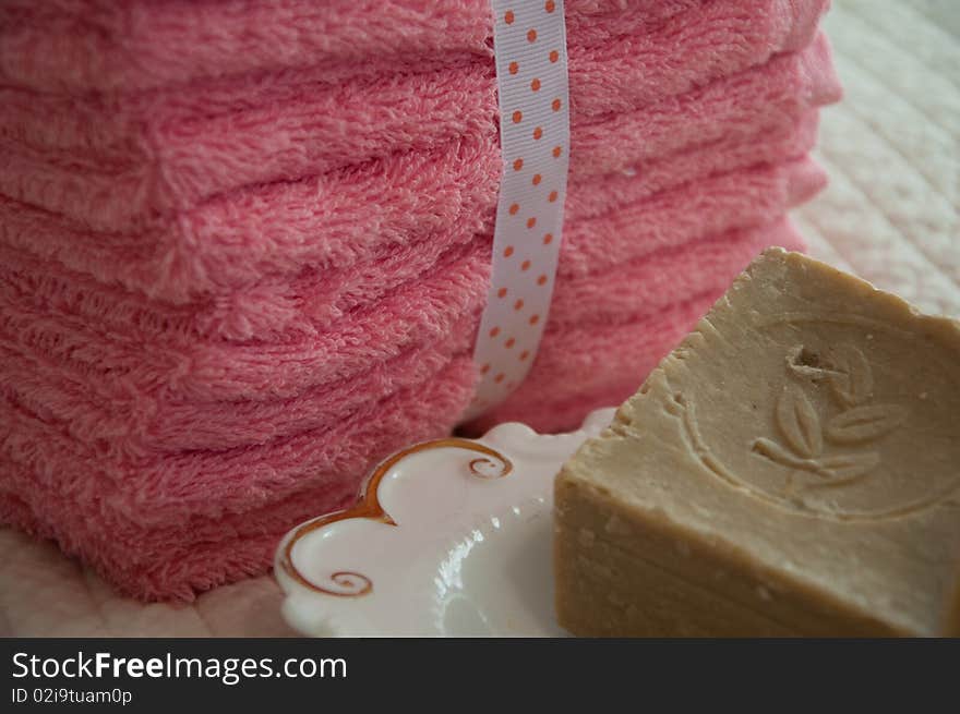 Rustic soap in a dish with a pile of washcloths nearby. Rustic soap in a dish with a pile of washcloths nearby.