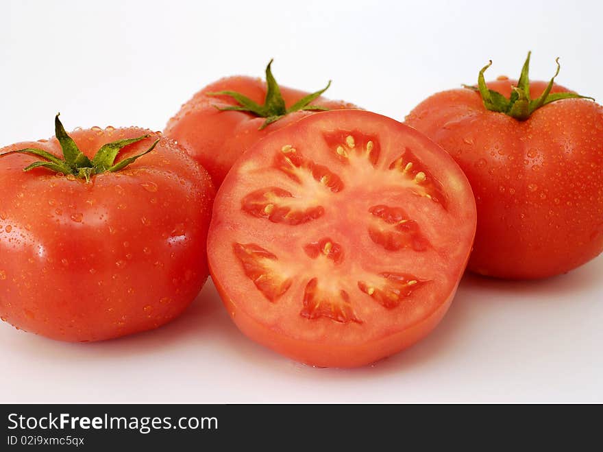 Red sprinkled tomatoes with water on the white background. Red sprinkled tomatoes with water on the white background