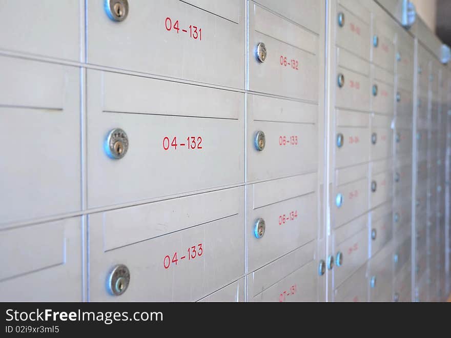 Row of metallic letter boxes with numbers and locks. For concepts such as safety and security, business communication and concepts. Row of metallic letter boxes with numbers and locks. For concepts such as safety and security, business communication and concepts.