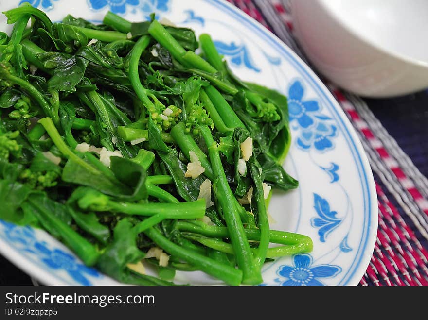 Closeup of green leafy vegetables stir fried and cooked oriental style. For concepts such as food and beverage, diet and nutrition, and healthy eating. Closeup of green leafy vegetables stir fried and cooked oriental style. For concepts such as food and beverage, diet and nutrition, and healthy eating.