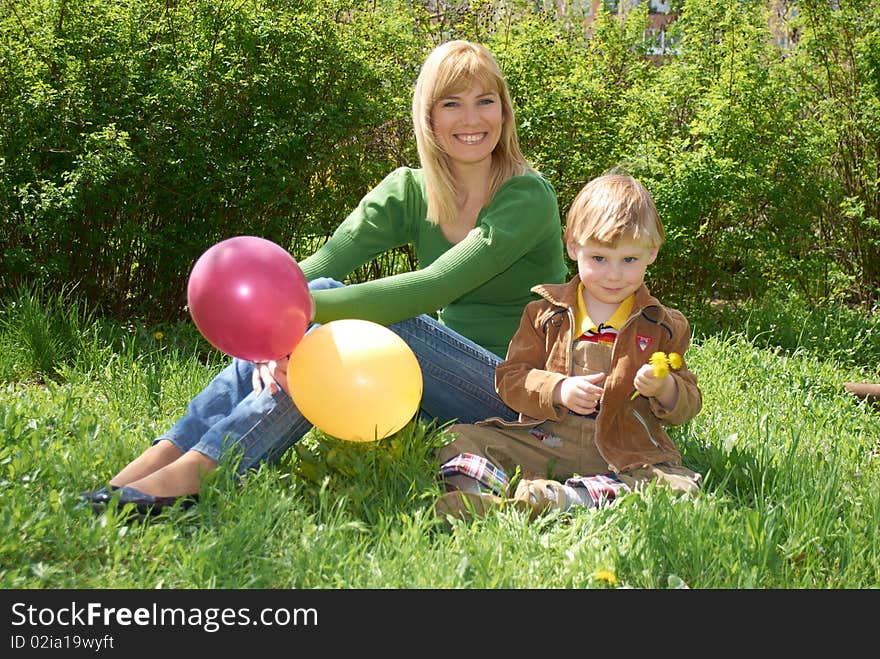 Mum with the son are played with balls in the spring on the nature. Mum with the son are played with balls in the spring on the nature