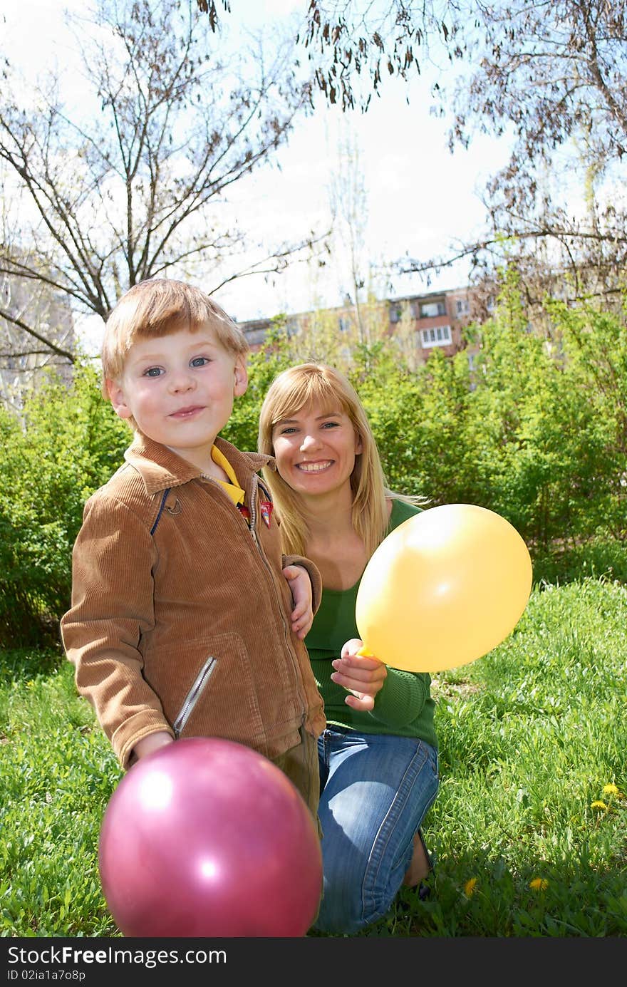 Mum with the son are played with balls in the spring on the nature. Mum with the son are played with balls in the spring on the nature