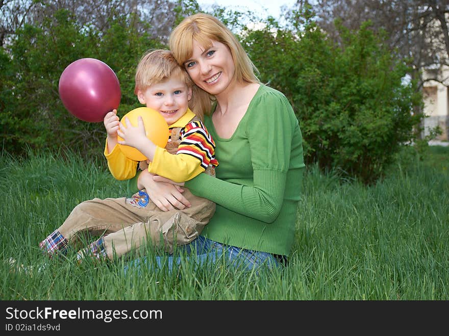 Mum with the son are played with balls in the spring on the nature. Mum with the son are played with balls in the spring on the nature