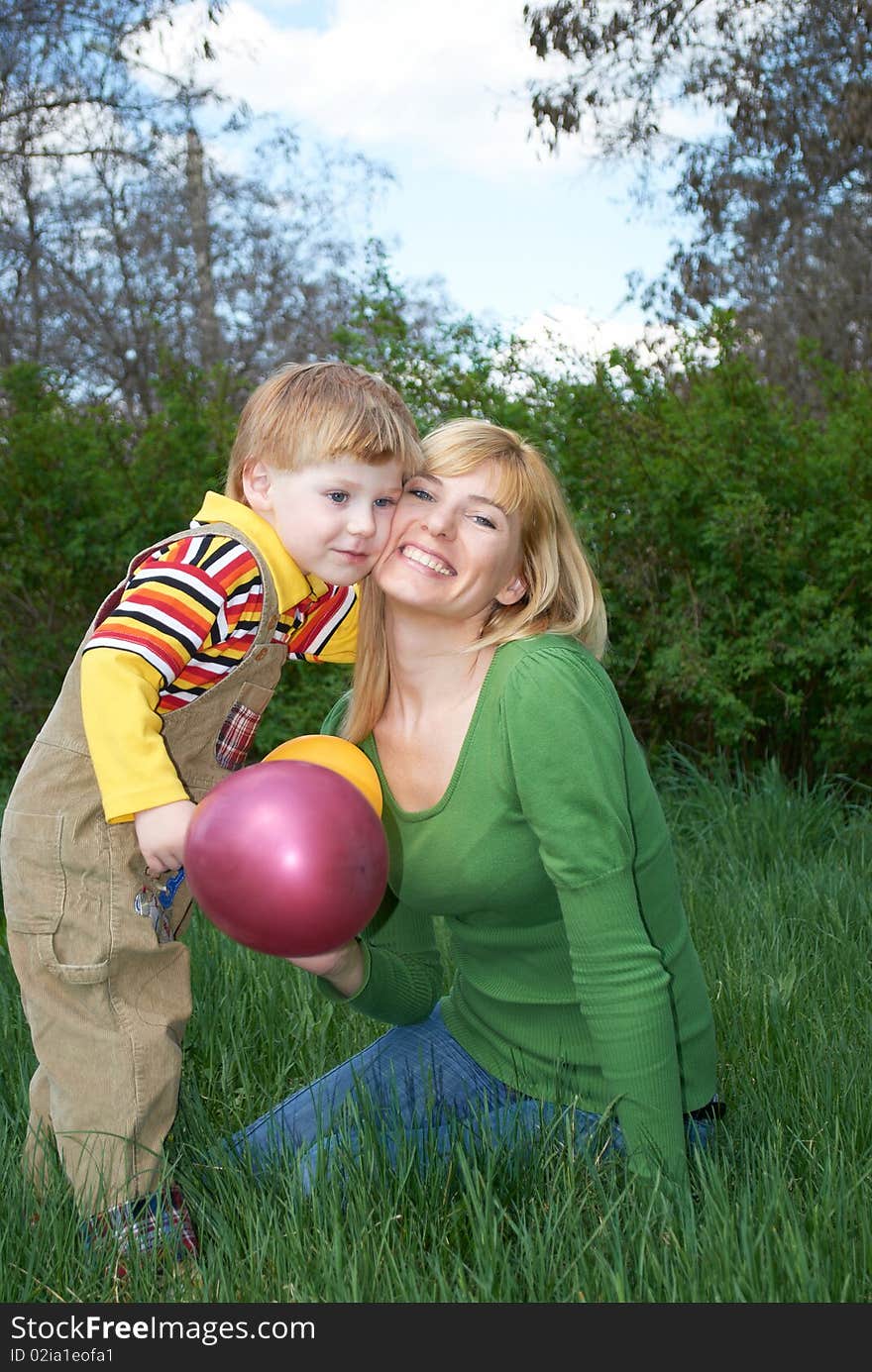 Mum with the son are played with balls in the spring on the nature. Mum with the son are played with balls in the spring on the nature