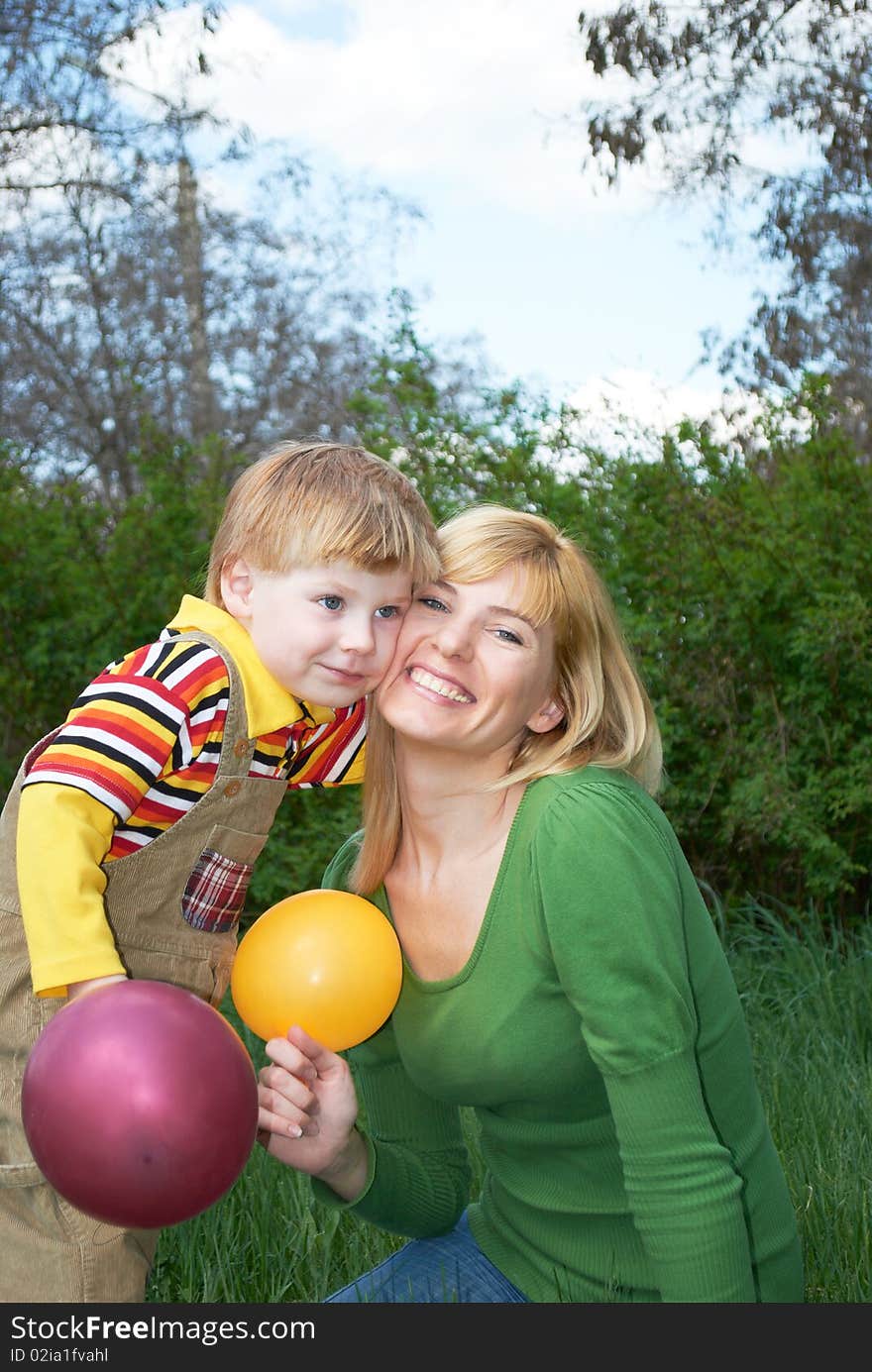 Mum with the son are played with balls in the spring on the nature. Mum with the son are played with balls in the spring on the nature