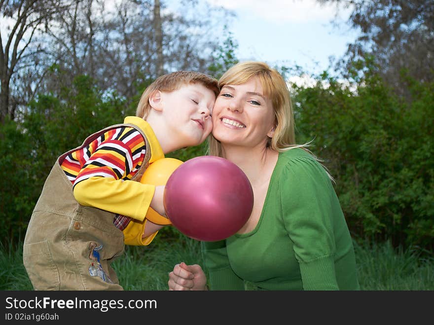 Mum with the son are played with balls in the spring on the nature. Mum with the son are played with balls in the spring on the nature