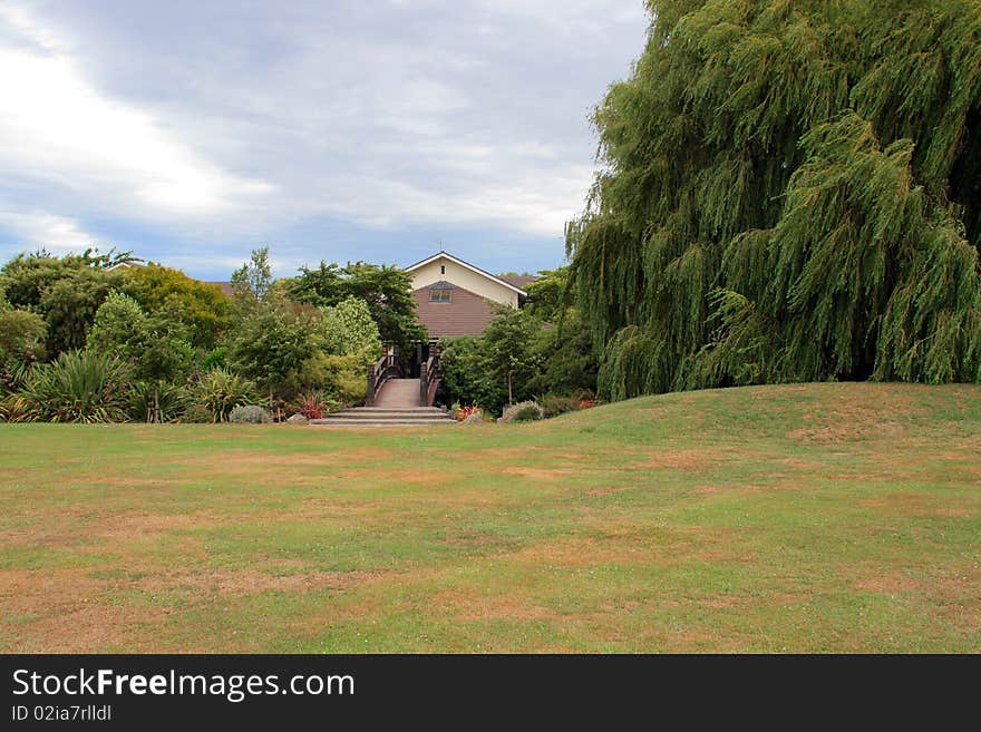 House and foot bridge among trees