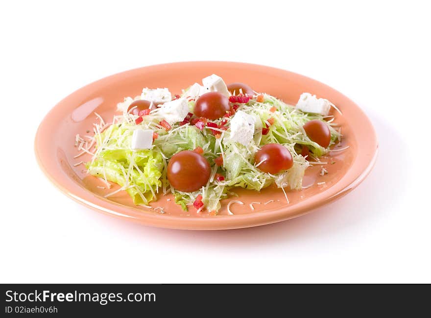 Fresh salad with feta and tomatoes on orange plate