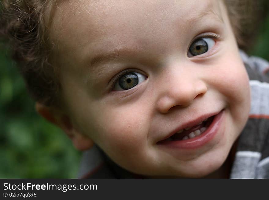 Cute young boy smiling, in an outdoor setting. Cute young boy smiling, in an outdoor setting.