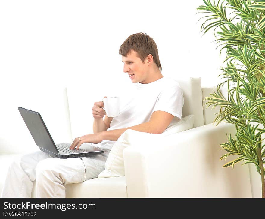 Miling young man working on laptop computer at home