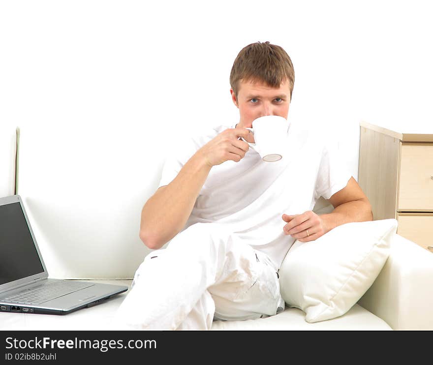 Smiling young man working on laptop computer at home