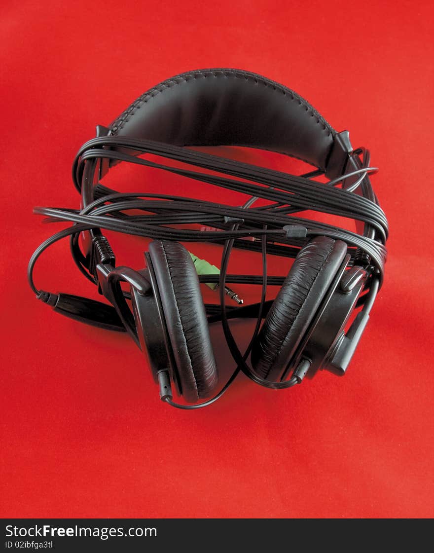 The  photo of a stereo headphones on red background. The  photo of a stereo headphones on red background