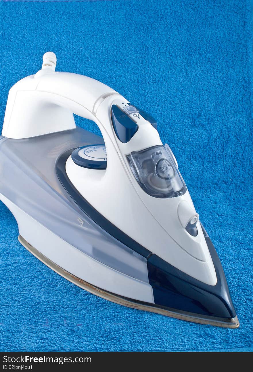 Electric iron on blue towel