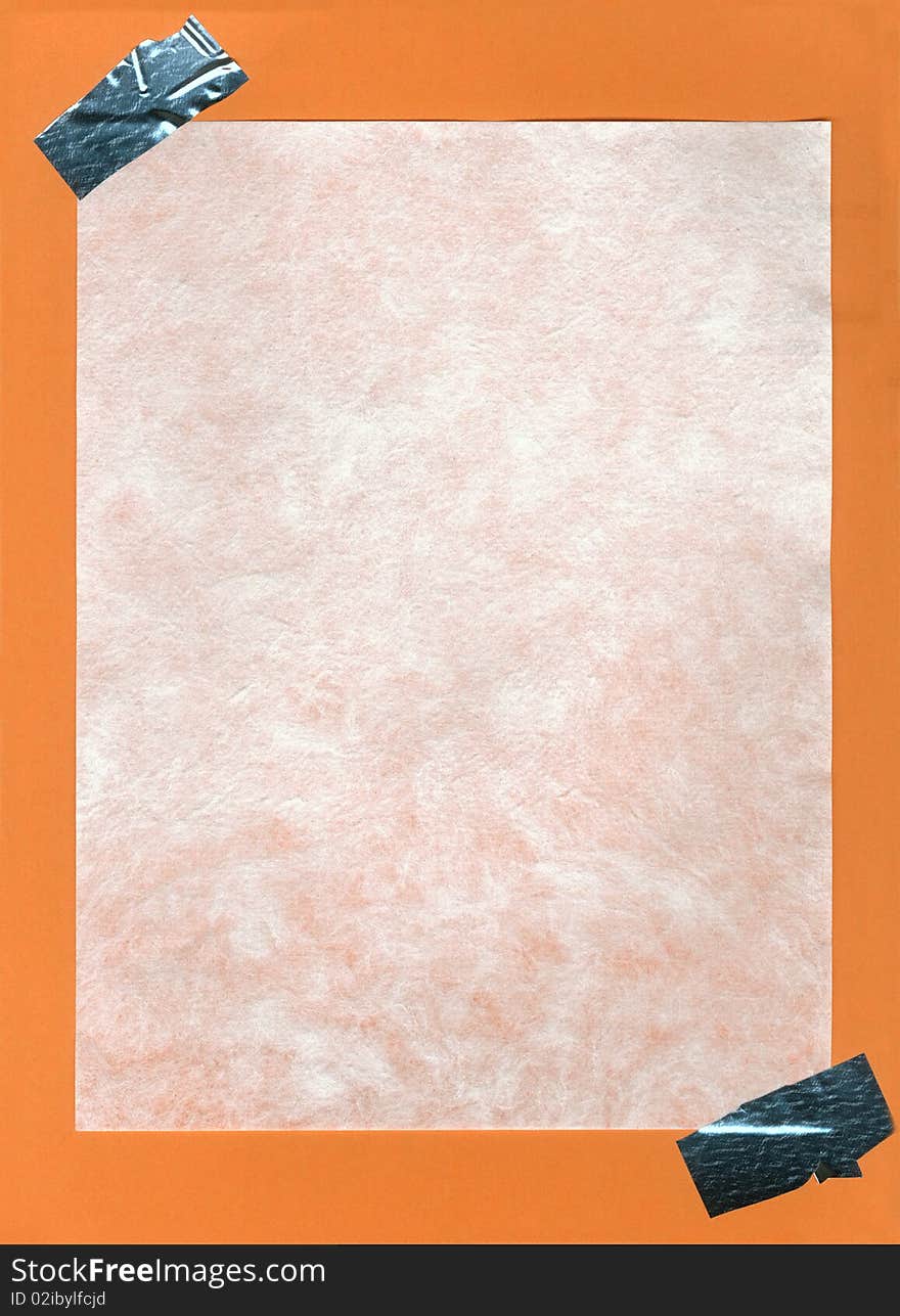 A piece of cotton paper with adhesive corners glued on orange paper