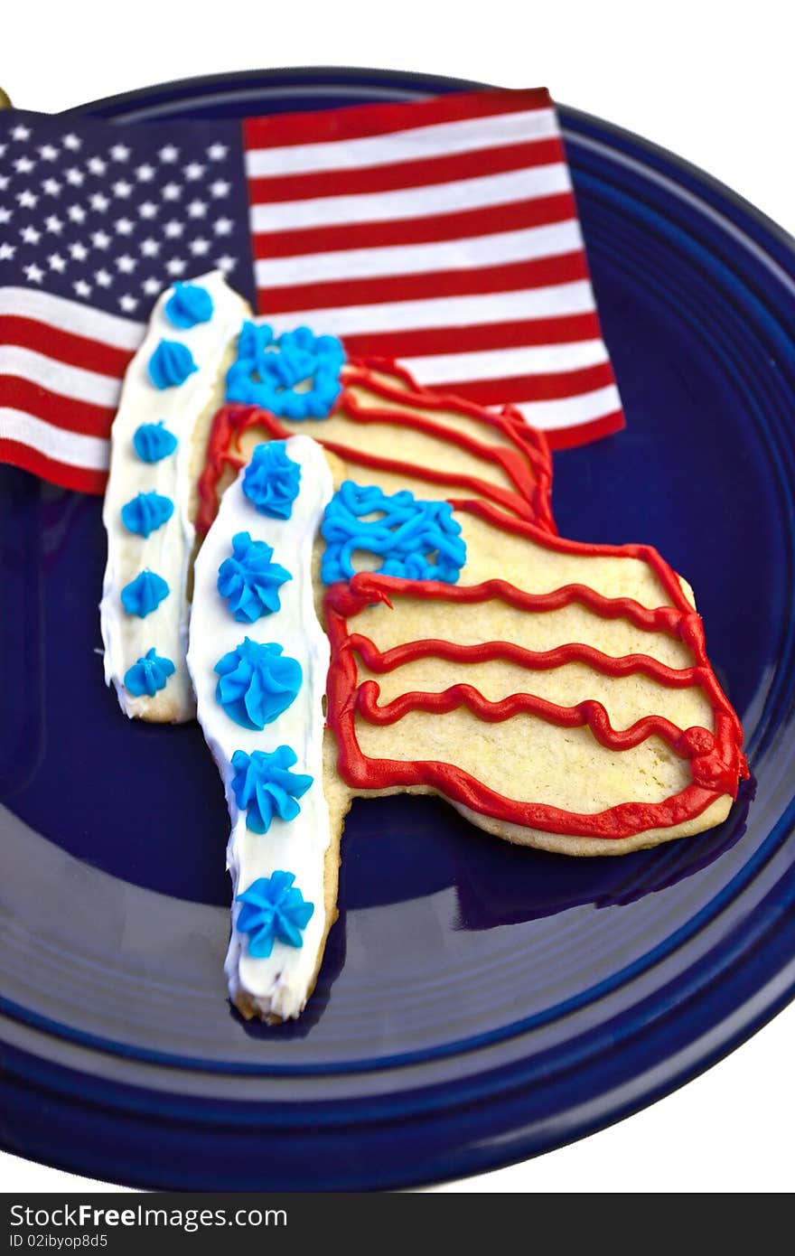 American flag and flag sugar cookies on a navy blue plate and isolated background. American flag and flag sugar cookies on a navy blue plate and isolated background.