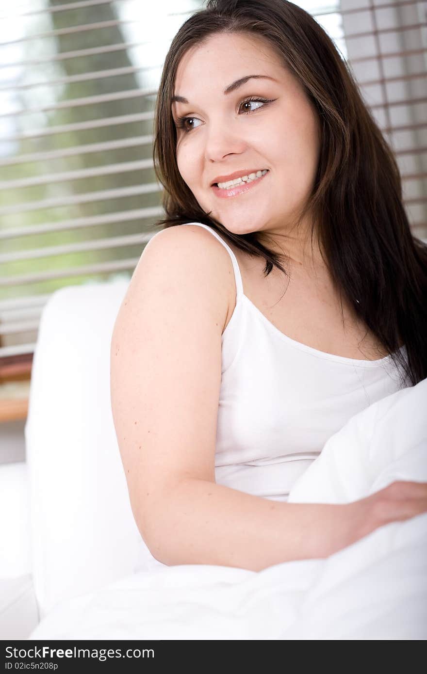 Young attractive brunette woman lying in bed. Young attractive brunette woman lying in bed