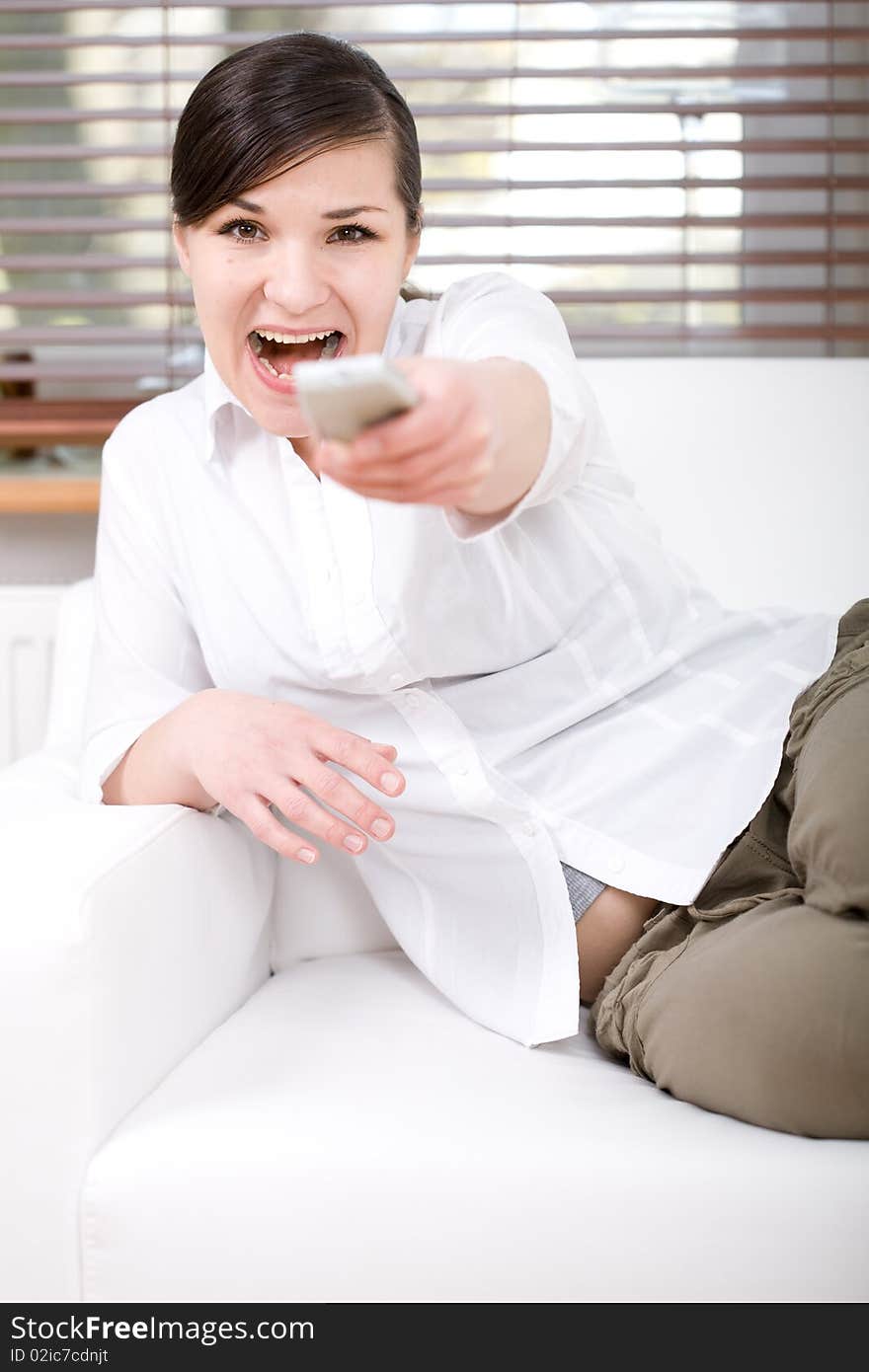 Young happy woman sitting on sofa with remote control. Young happy woman sitting on sofa with remote control