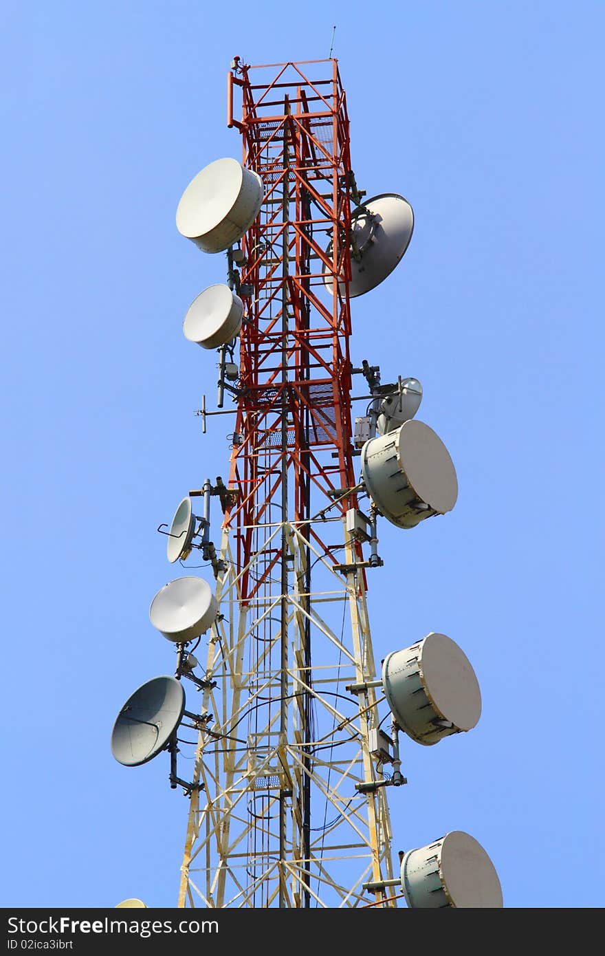 A telecommunications tower with a clear blue sky