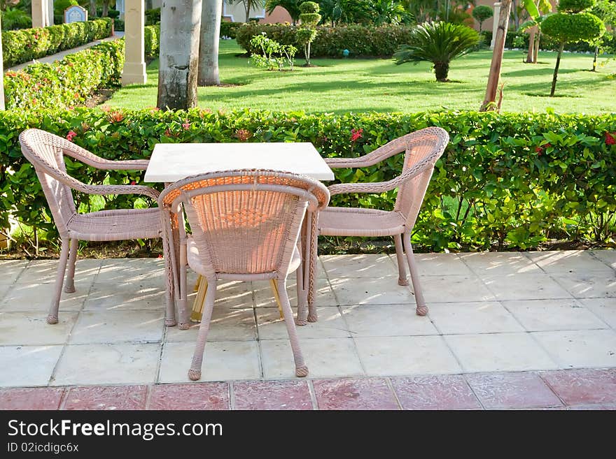 Brown wooden chairs an tables on patio in the morning