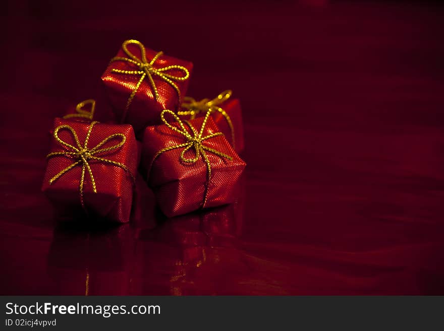 Close-up photograph of small red gift boxes on an abstract red background. Good for use with Valentines Day and Christmas themes. Close-up photograph of small red gift boxes on an abstract red background. Good for use with Valentines Day and Christmas themes