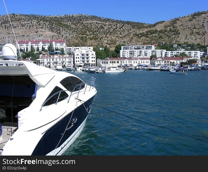 Yacht berthed in the bay against the backdrop of blue sea. Yacht berthed in the bay against the backdrop of blue sea