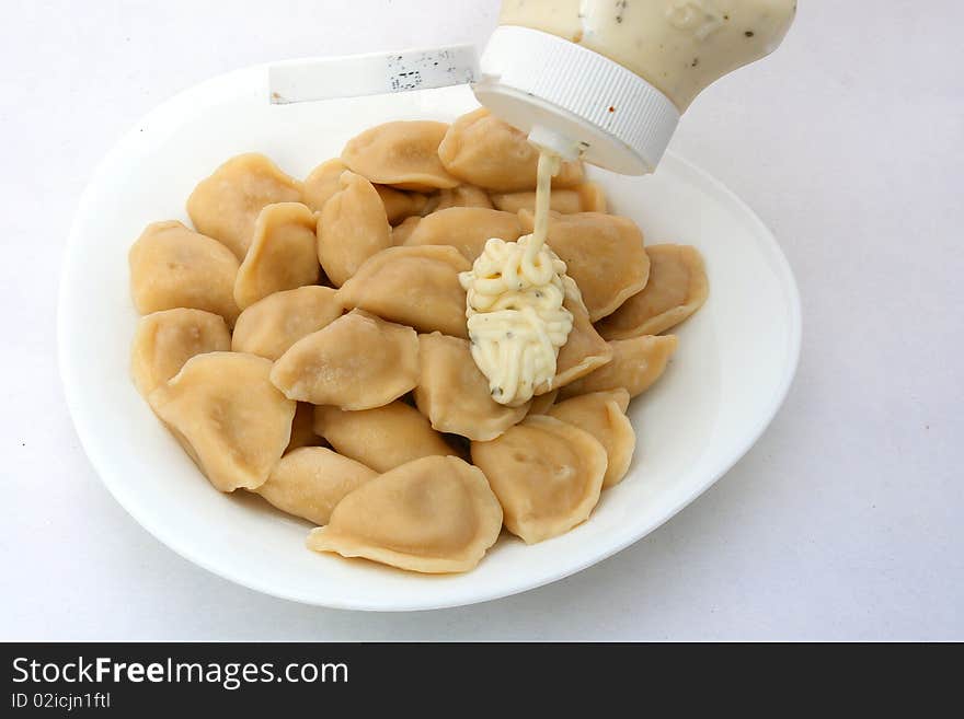 Ravioli in plate close-up on white background